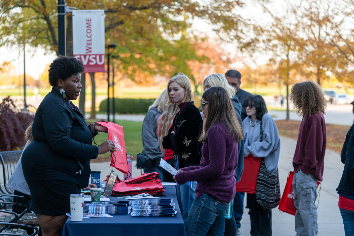 Students around table talking to SVSU rep